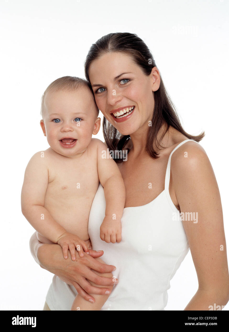 Mother with straight brunette hair holding her baby, at her hip, baby and mother looking straight to camera smiling Stock Photo