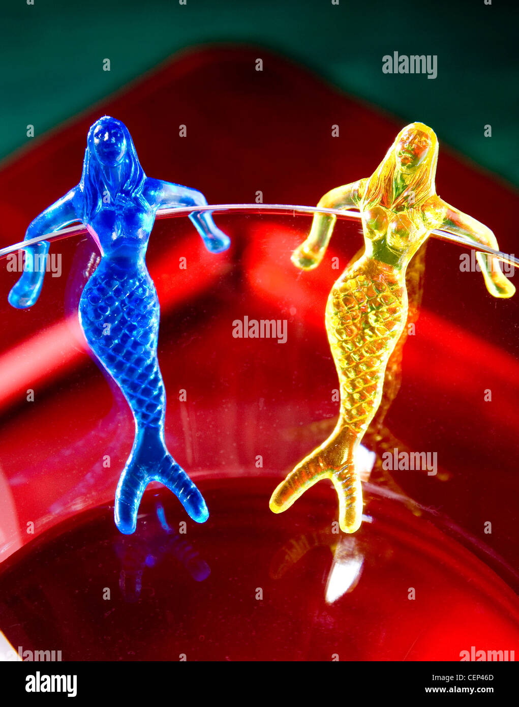 Horoscopes Gemini Two plastic mermaids clipped on to the side of a glass Stock Photo
