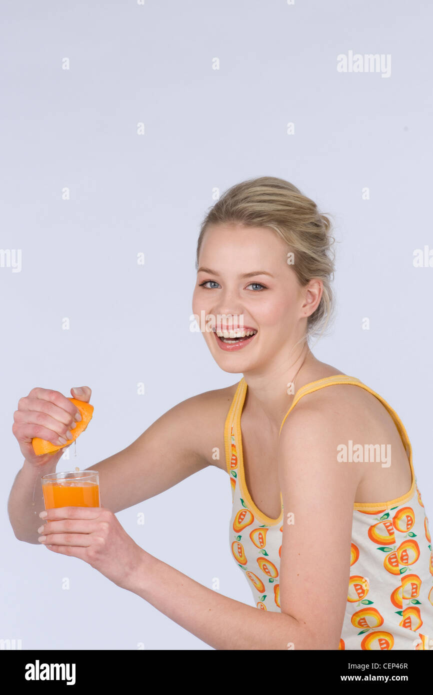 Female Dark Blonde Hair Tied Back Wearing A White Top An Orange
