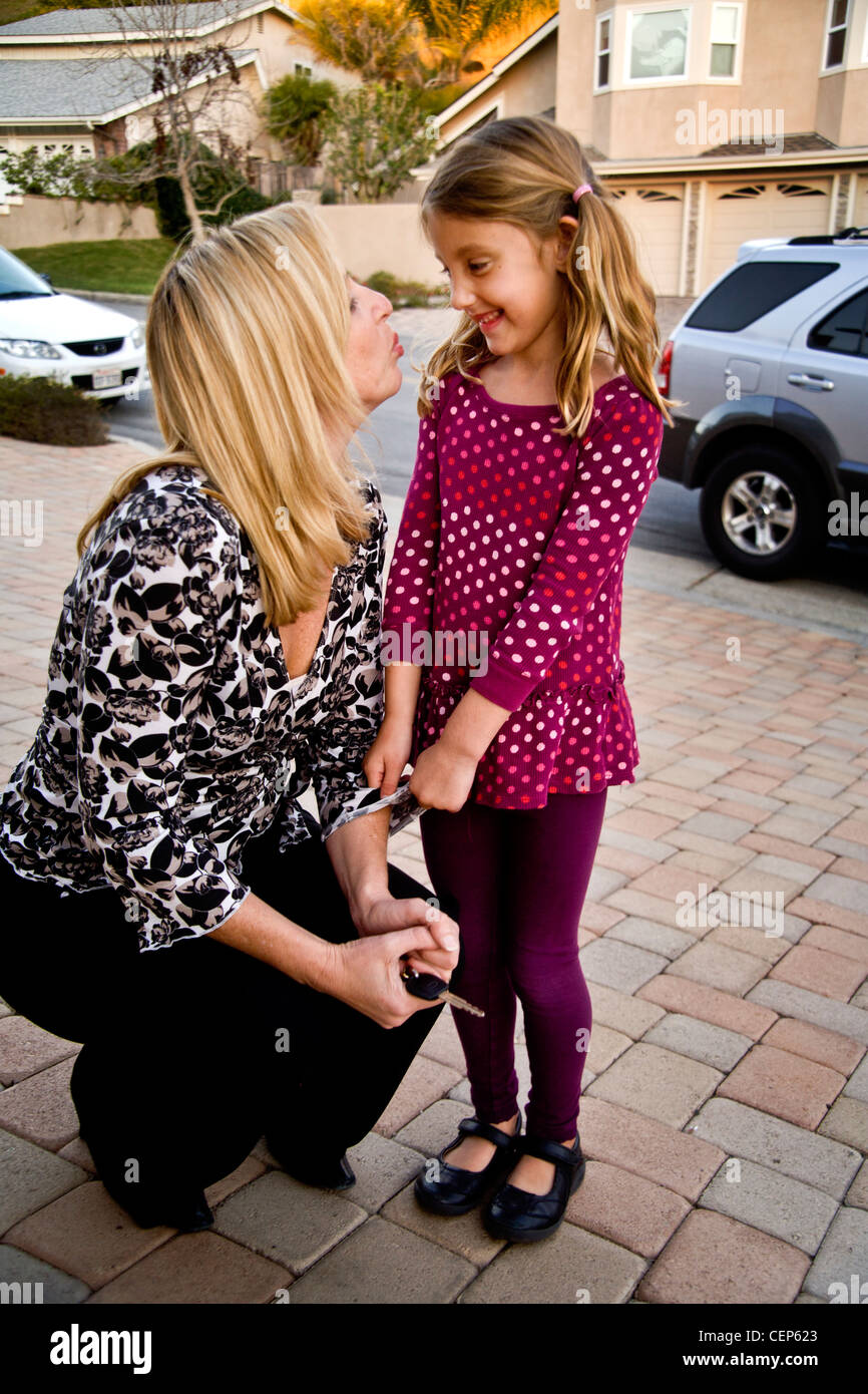 A 29 year old mother and her 6 year old daughter on their suburban street in San Juan Capistrano, CA. MODEL RELEASE Stock Photo