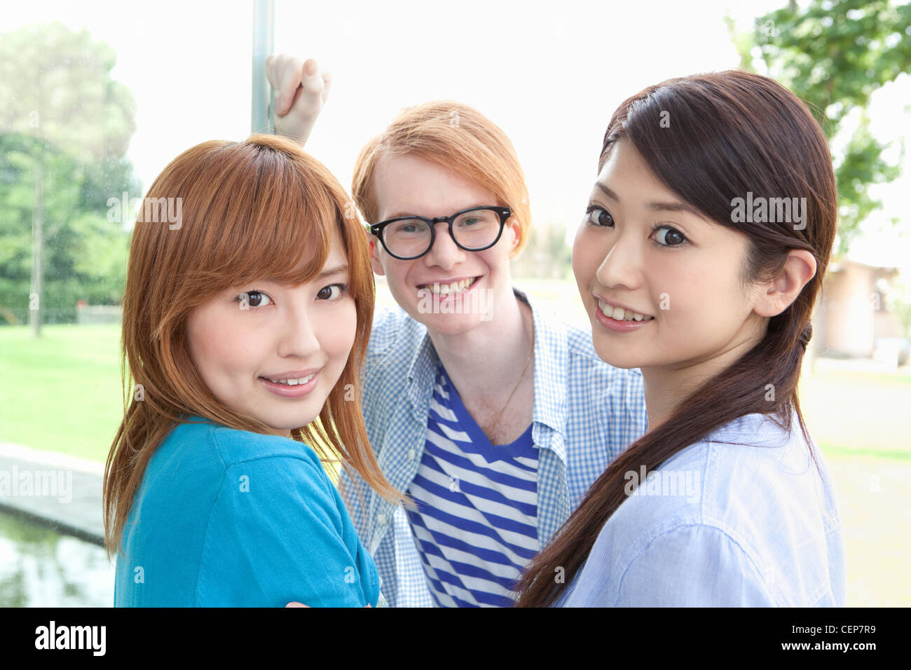 Young man and two young women smiling Stock Photo - Alamy