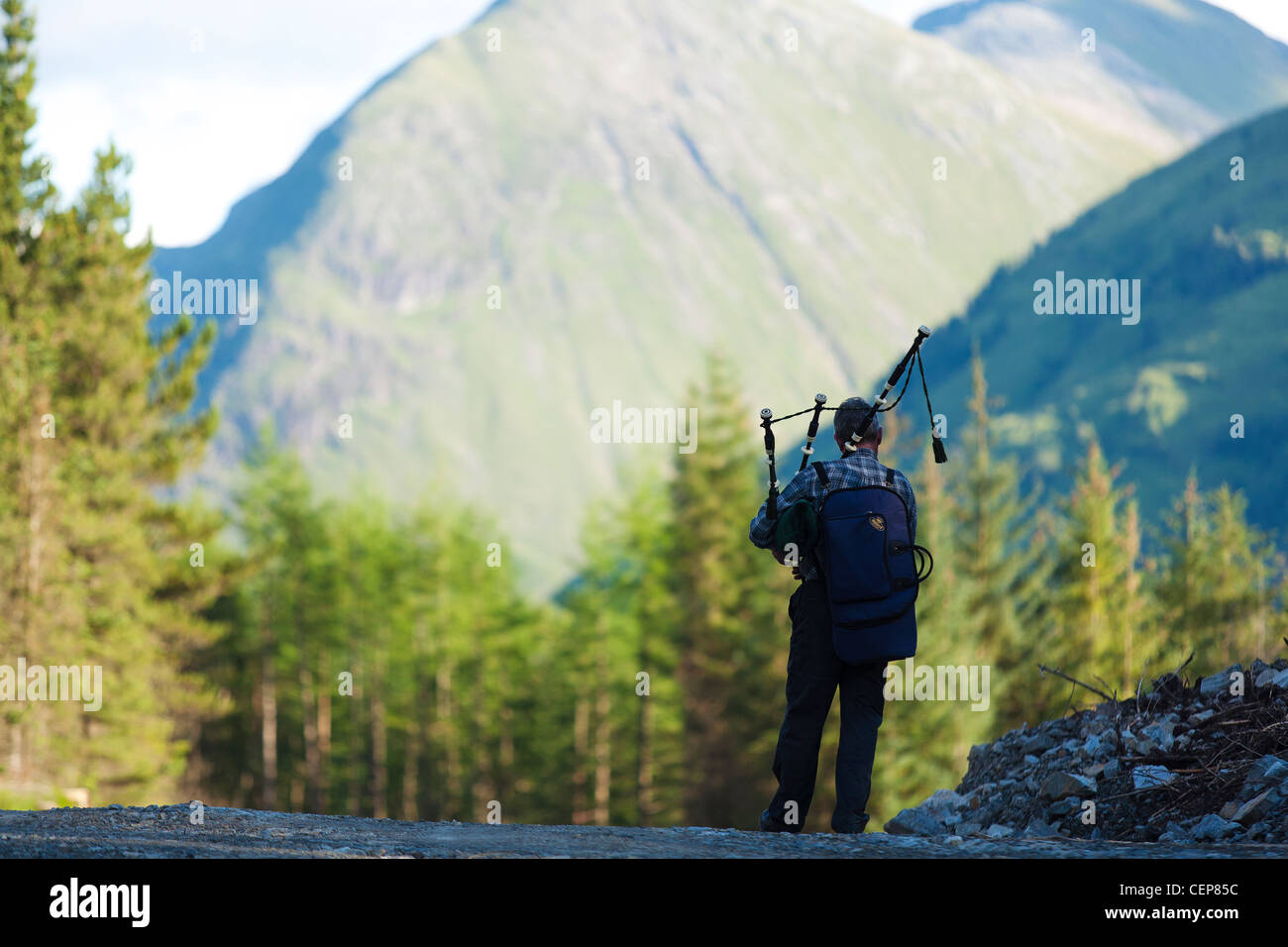 A man practices with his bagpipes in Glencoe in the Scottish highlands, an area of extreme natural beauty and important history. Stock Photo
