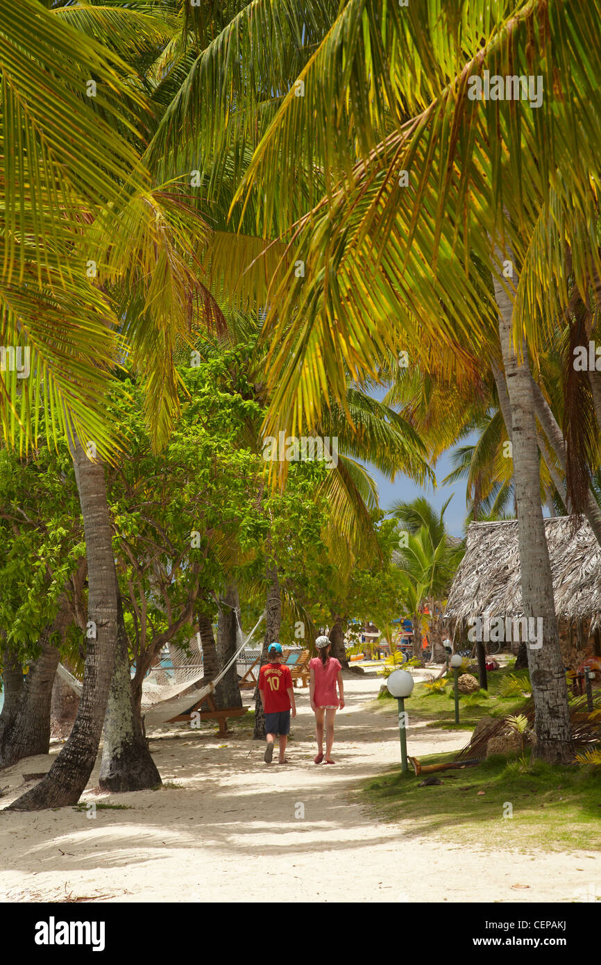 Children walking along palm fringed path, Plantation Island Resort, Malolo Lailai Island, Mamanuca Islands, Fiji, South Pacific Stock Photo