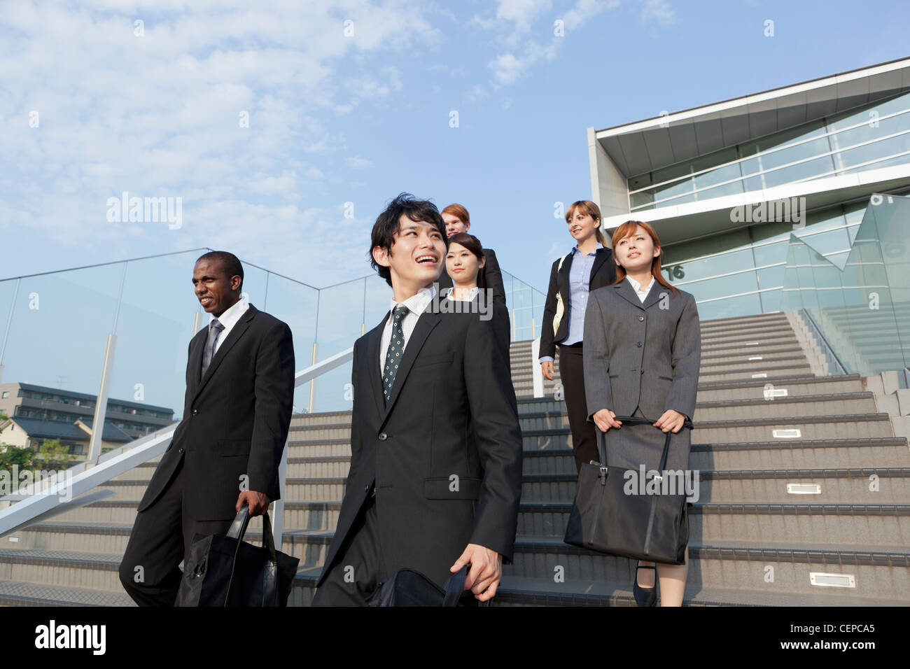 Businessmen and businesswomen getting down steps Stock Photo - Alamy