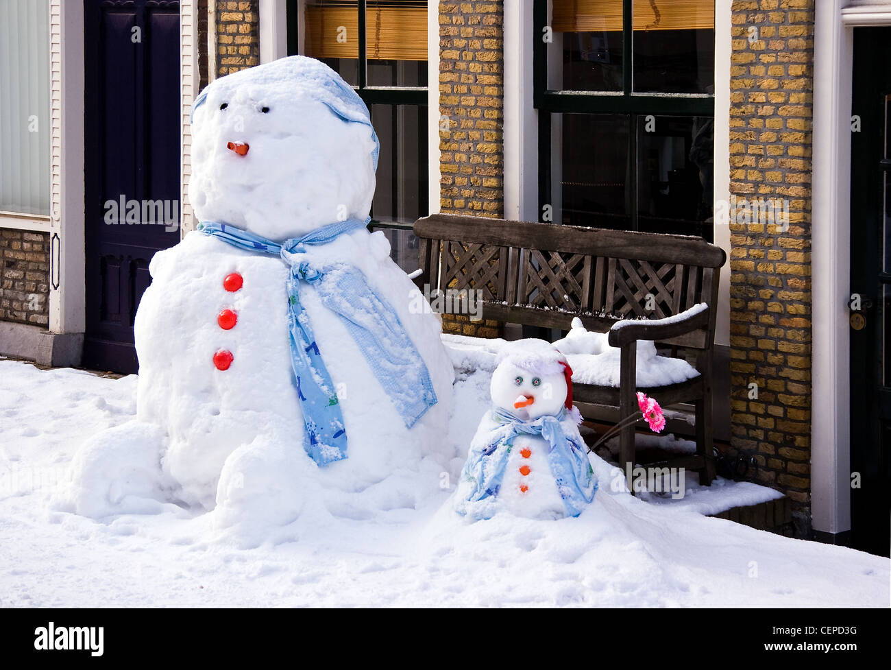 Funny Snowman and son in front of house in the street - horizontal image Stock Photo