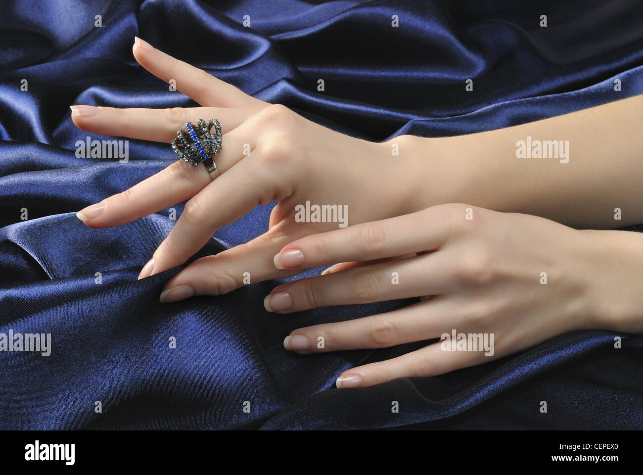 Close-up woman's hands with ring on silky blue background Stock Photo ...