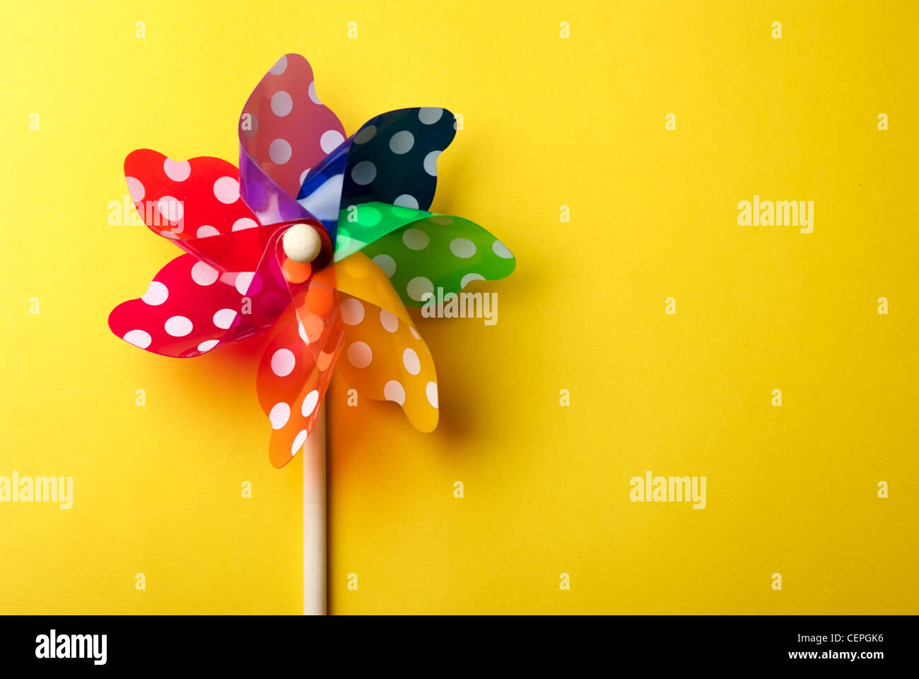 Childrens colorful windmill toy isolated on yellow background Stock Photo