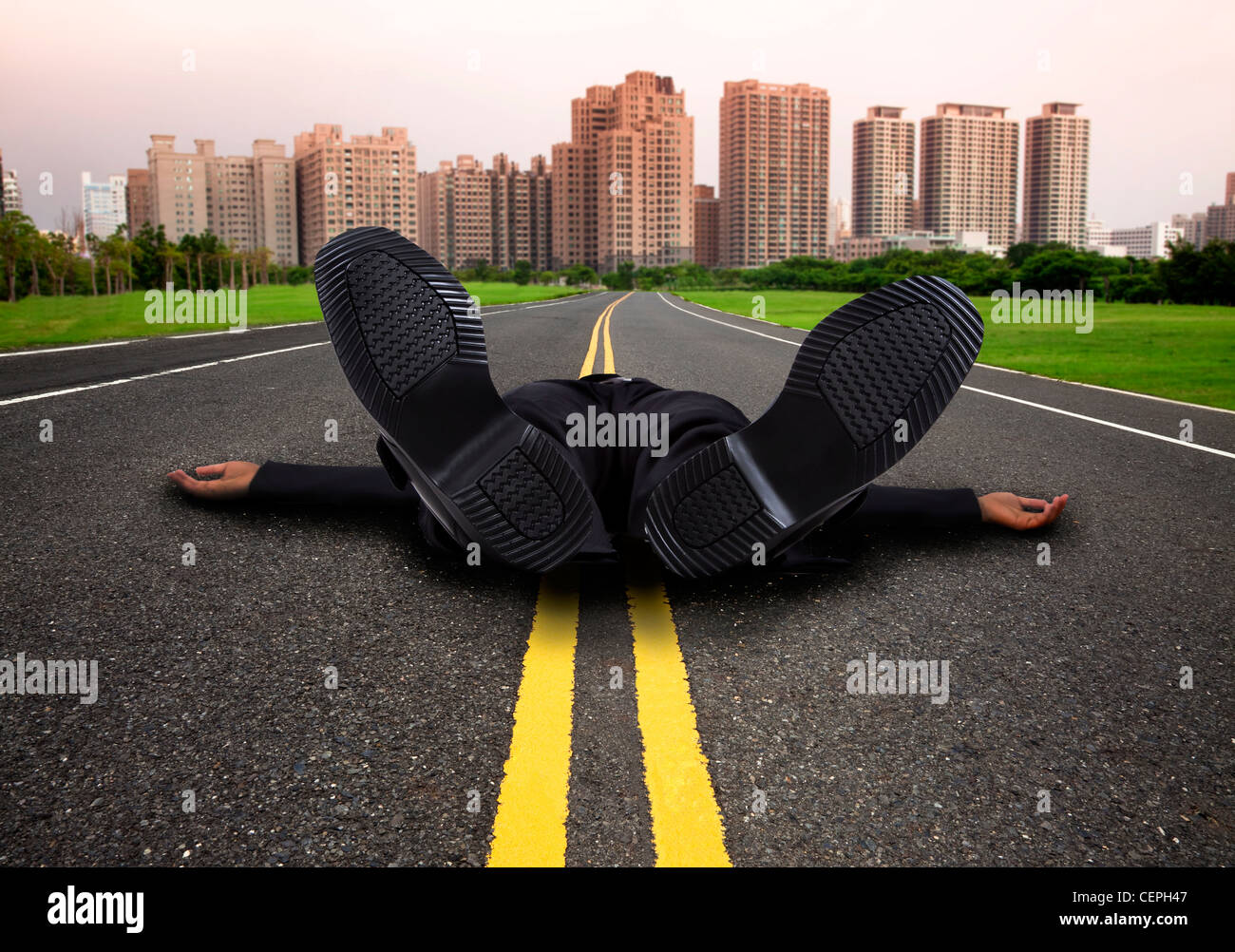 businessman tired and Exhausted on the empty road to the city Stock