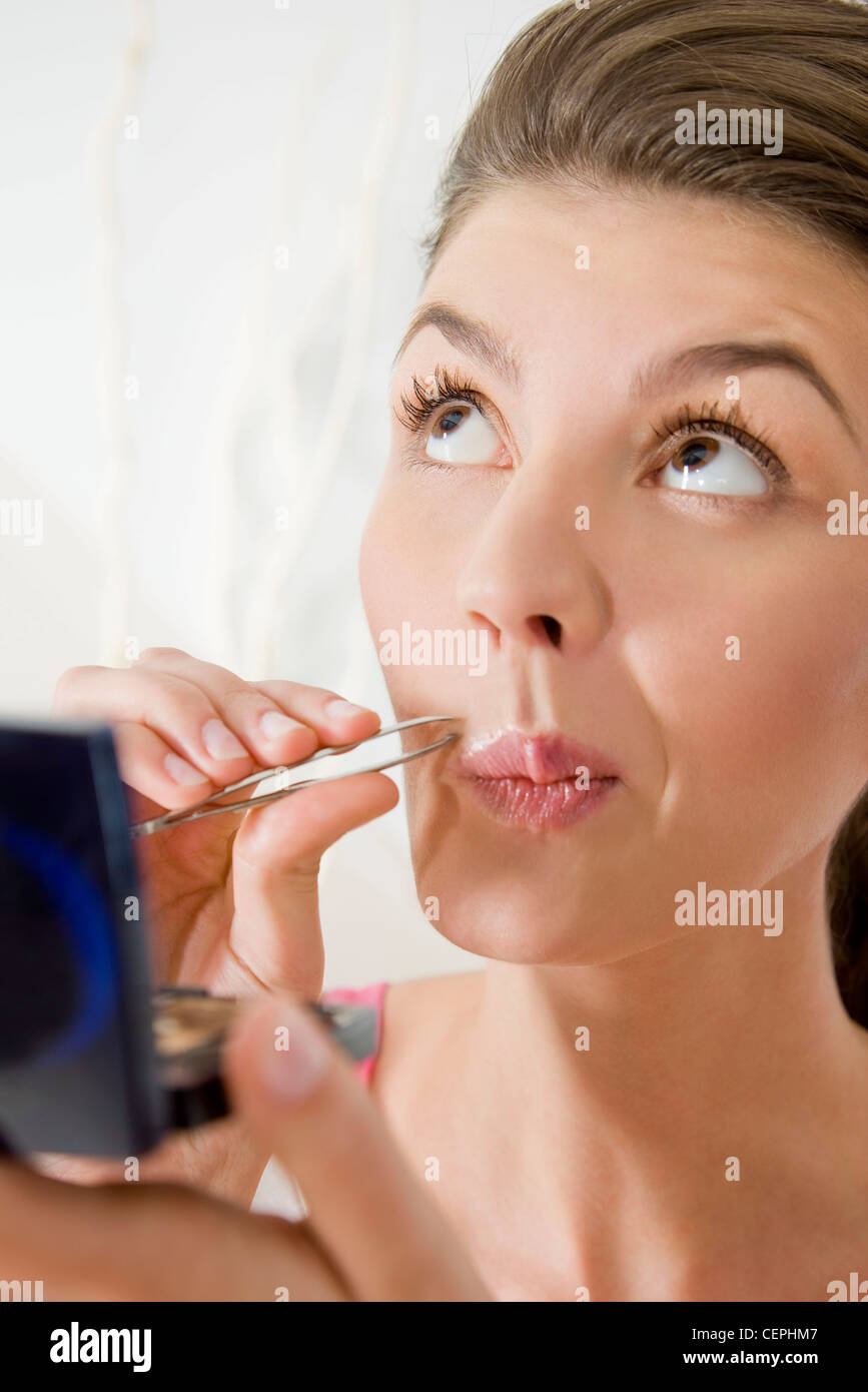 Woman plucking her facial hair Stock Photo Alamy