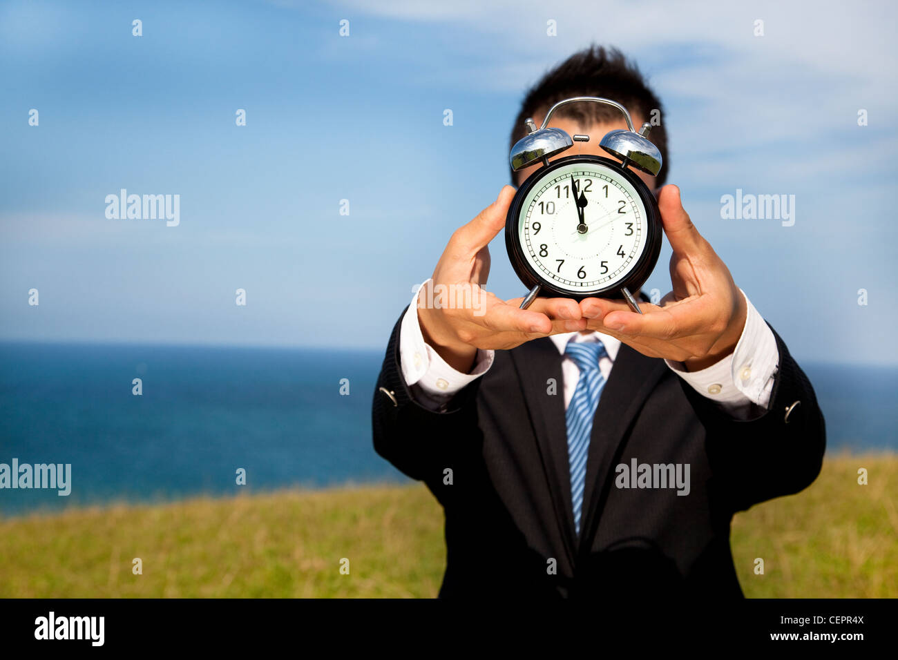 man holding clock and cover his face Stock Photo