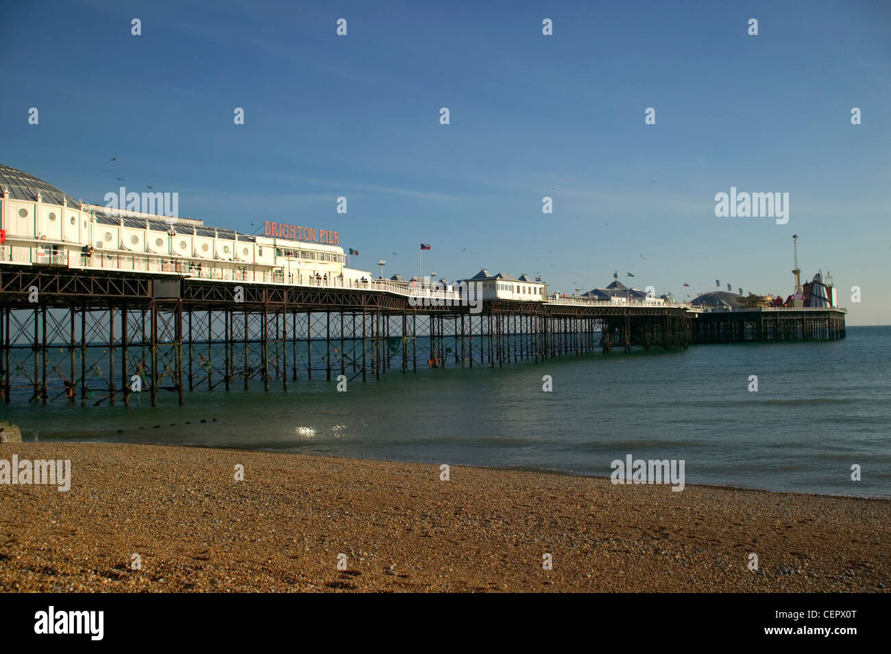 Brighton Pier, a Grade 2 listed building, from the pebble beach in Brighton. The pier is 1722 feet long and acknowledged as the Stock Photo