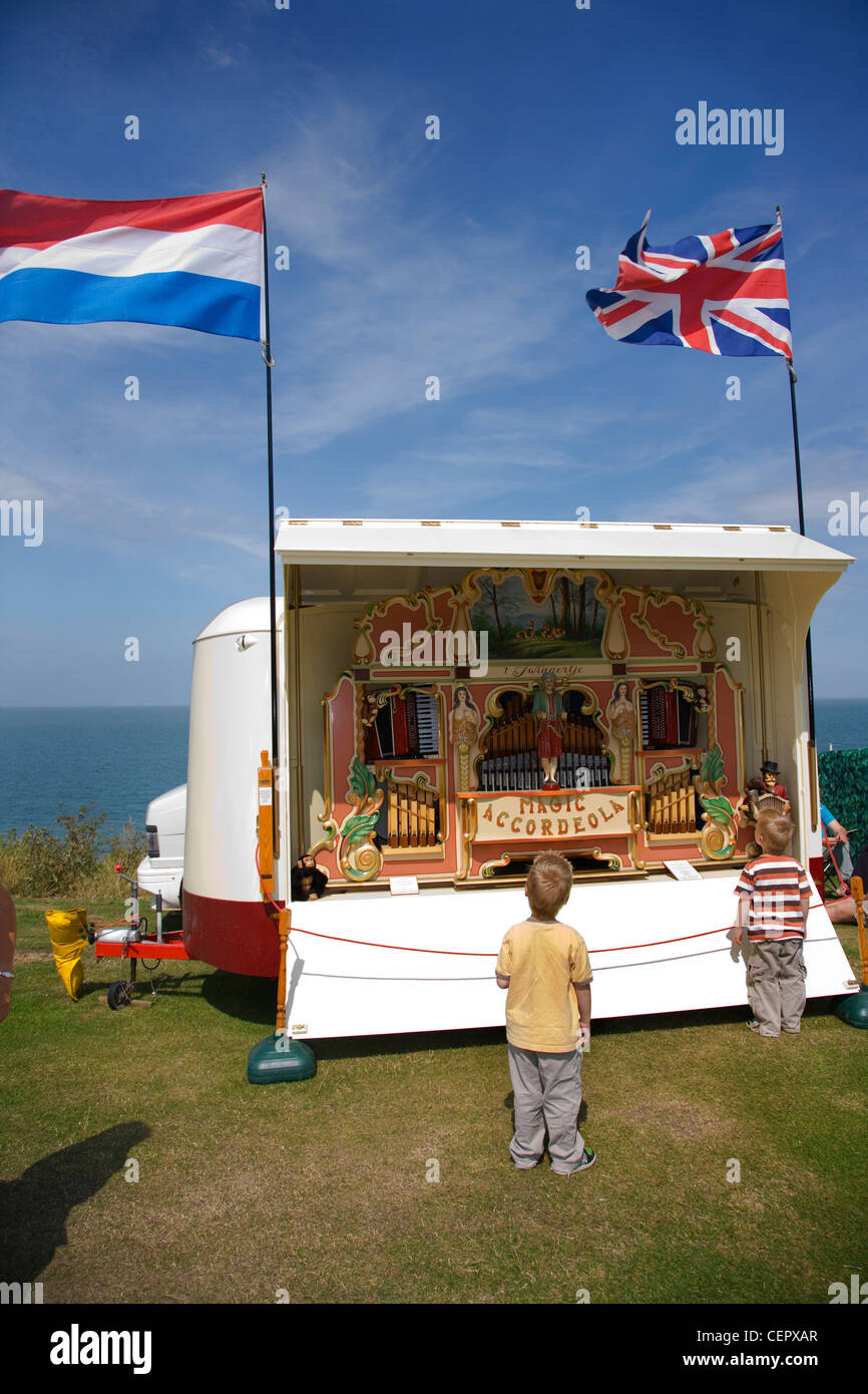 Two young boys looking at a 41-key Heesbeen 'Magic Accordeola' fair organ by the seafront at a fair in Whitstable. Stock Photo