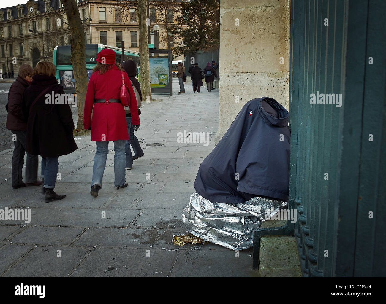 Sleeping Against Railing Urban misery. Blue, white, red, The cold A homeless sleeping sitting ...