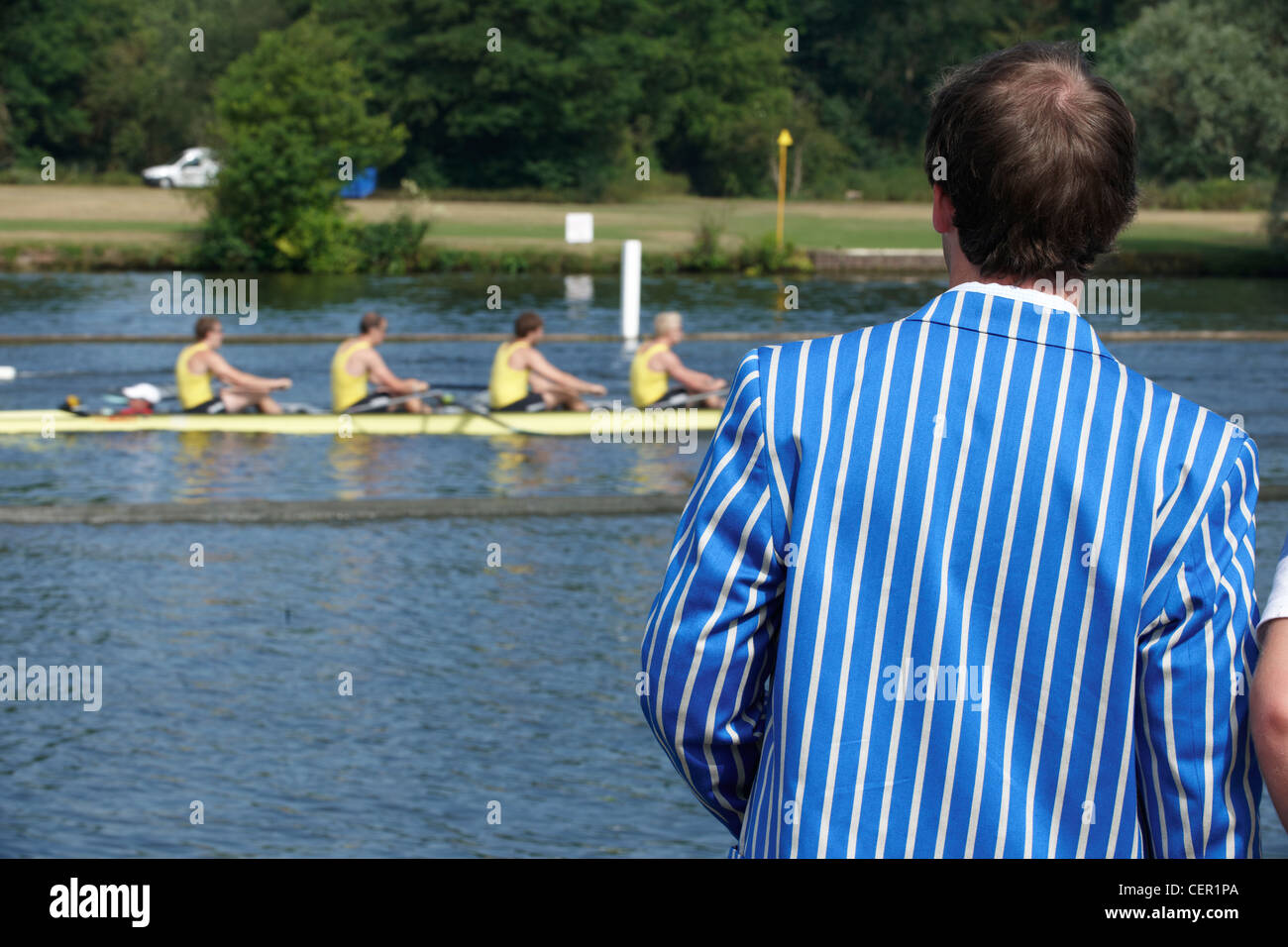 A spectator wearing a rowing club blazer watching a race from the riverside at the annual Henley Royal Regatta. Stock Photo