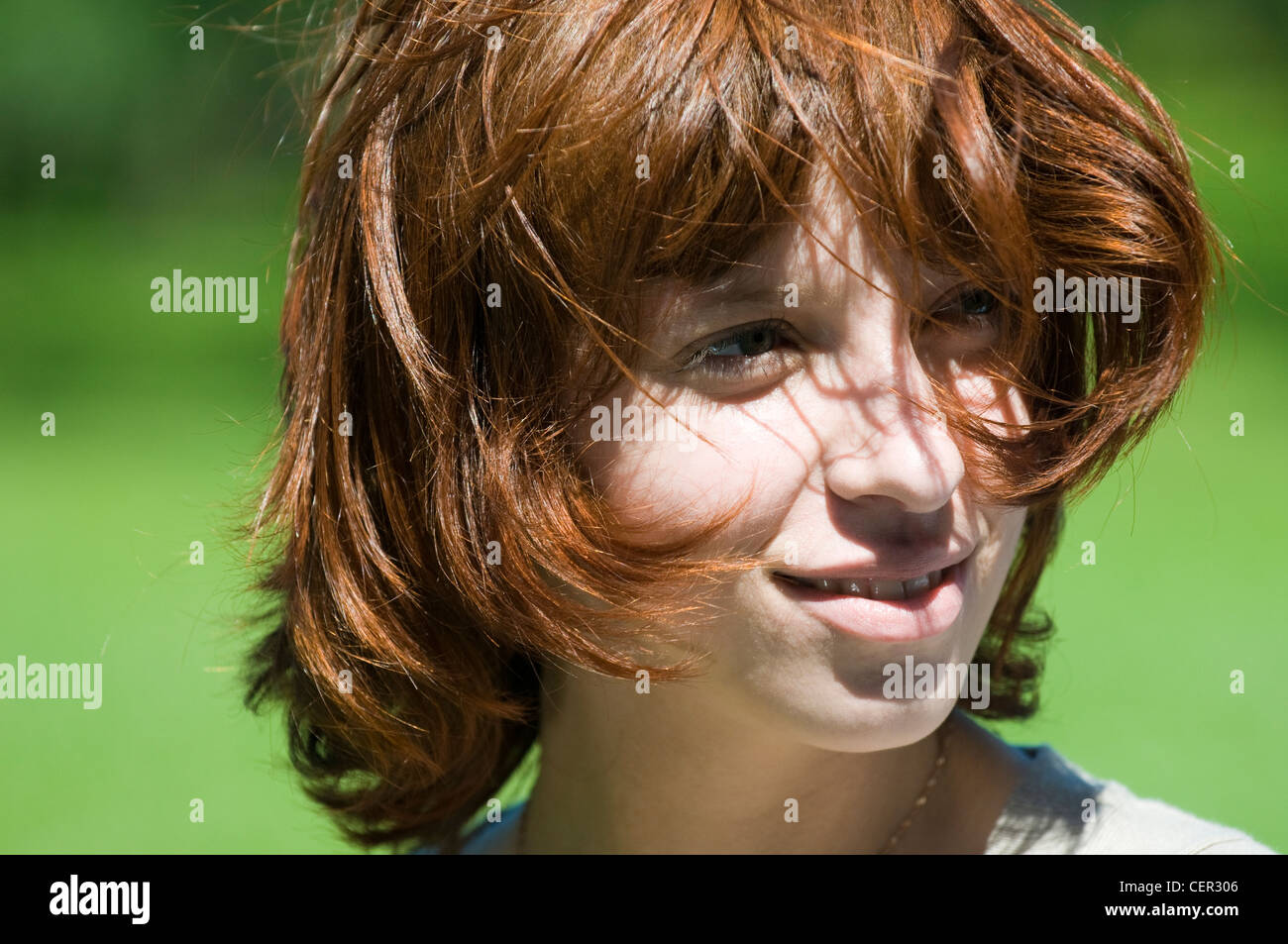 Young red haired girl in a green park Stock Photo - Alamy