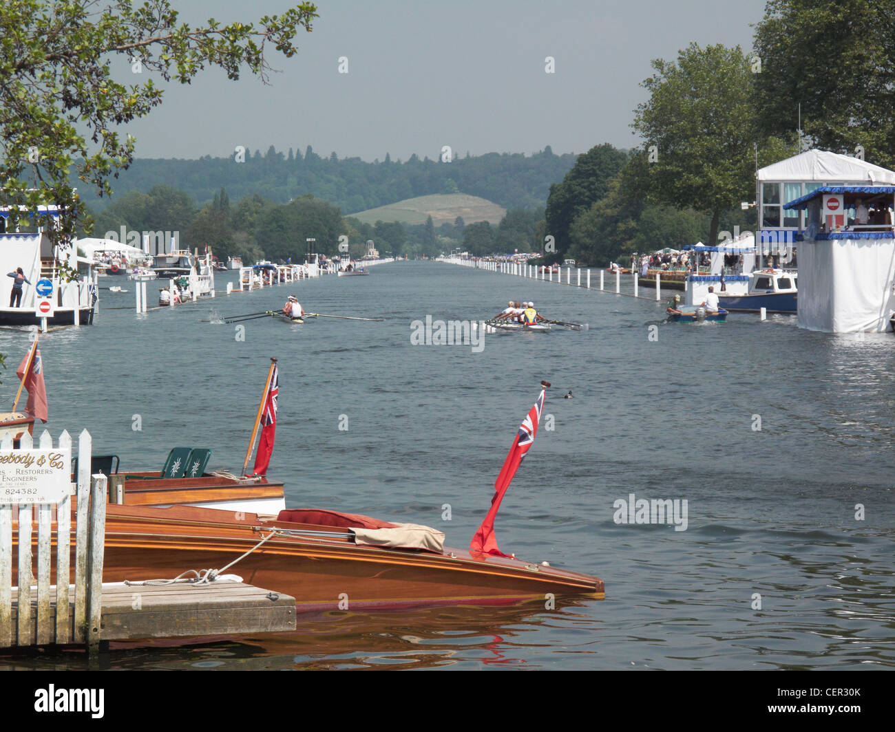 A view down the course of two crews completing a race at the annual Henley Royal Regatta. Stock Photo