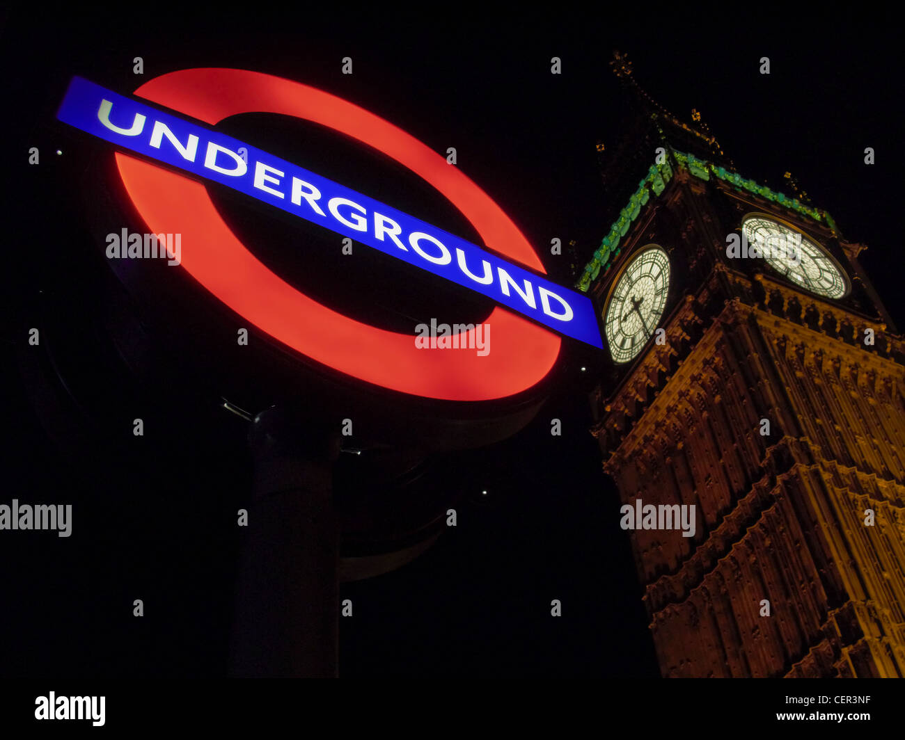 Illuminated underground sign in front of Big Ben at night in Westminster. Stock Photo