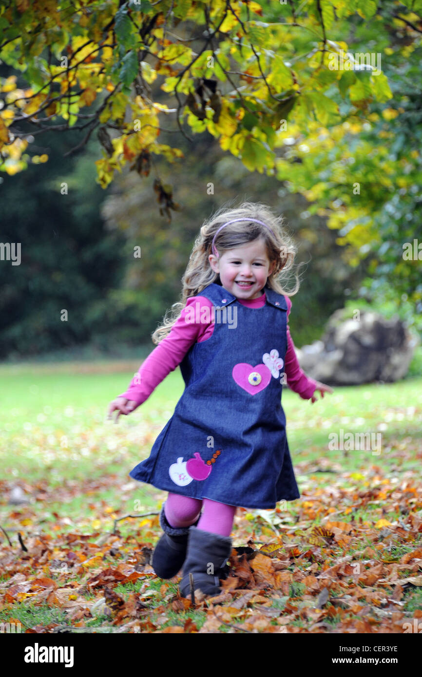 A young girl running through autumnal leaves on Hubbard's Hills. Stock Photo