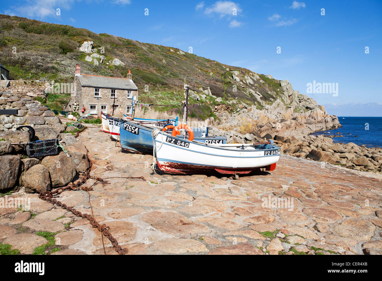 Traditional fishing boats and cottage by the sea at Penberth. Stock Photo