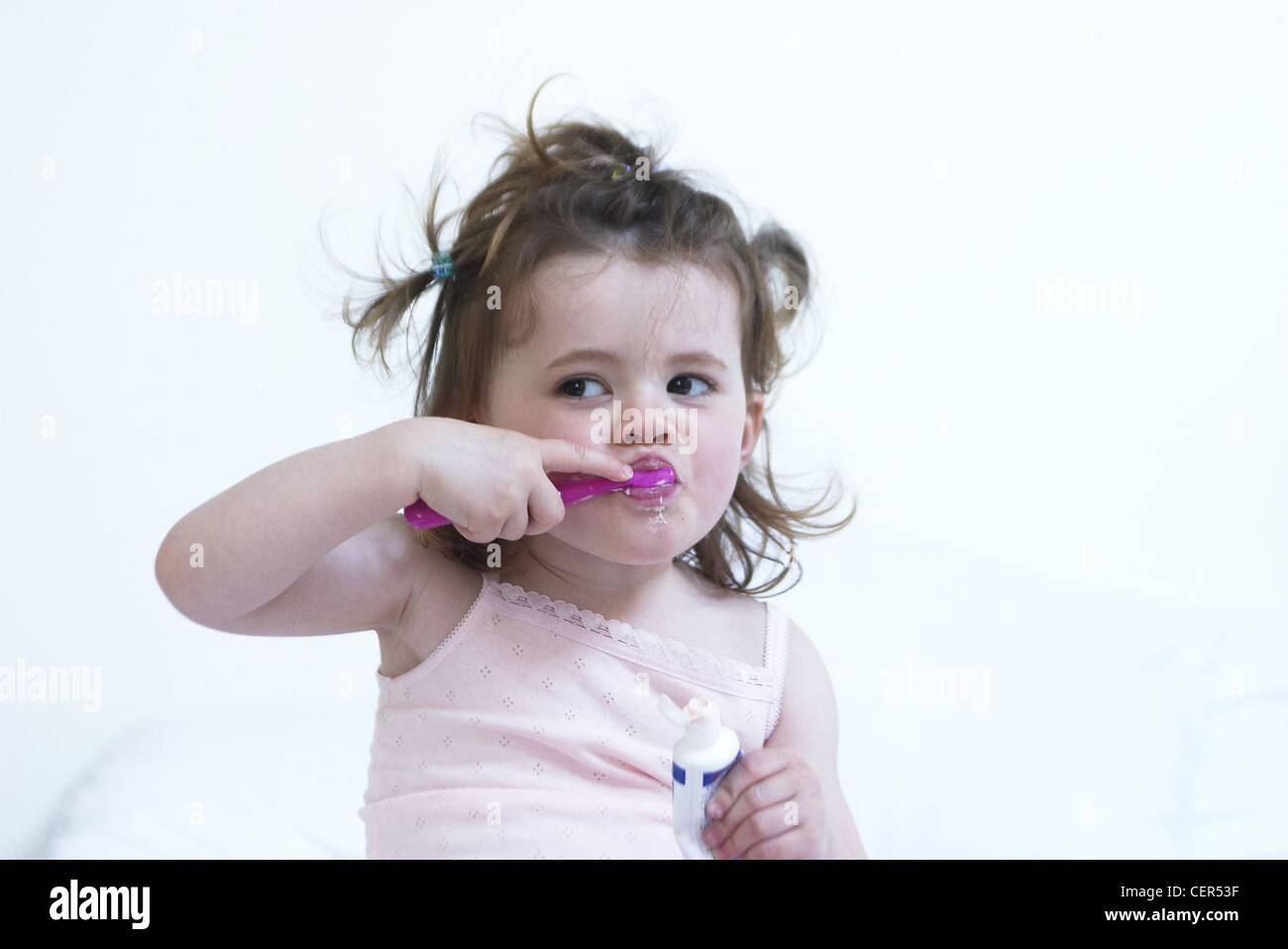 Female Child Brunette Hair Tied Up In Mini Bunches Wearing Pink
