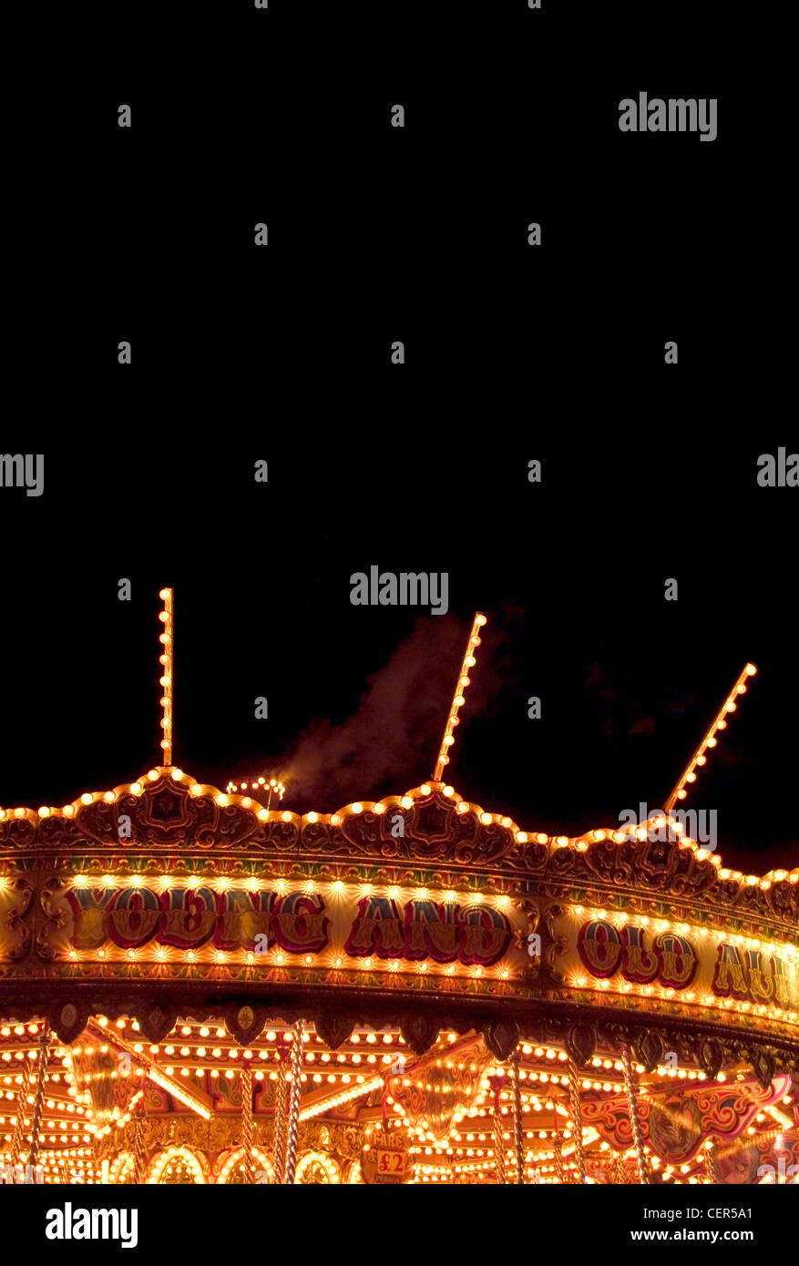 Carousel at night. The word carousel originates from the Italian garosello meaning 'little war', used by crusaders to describe a Stock Photo