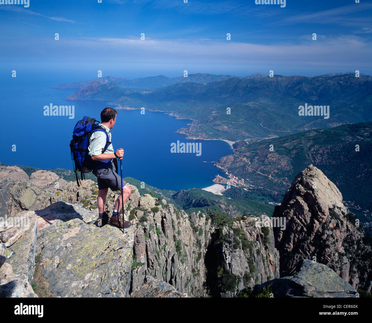 Man standing on the summit of Capu d'Orty with view over the Golfe de Porto, Corsica, France. Stock Photo