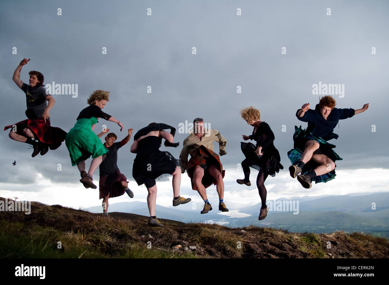 Group celebrating summer solstice by jumping and dancing in the air at