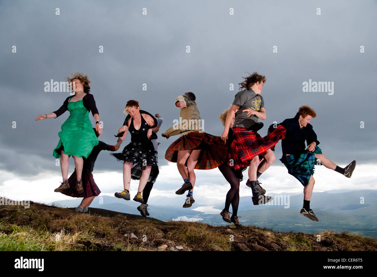 Group celebrating summer solstice by jumping and dancing in the air at