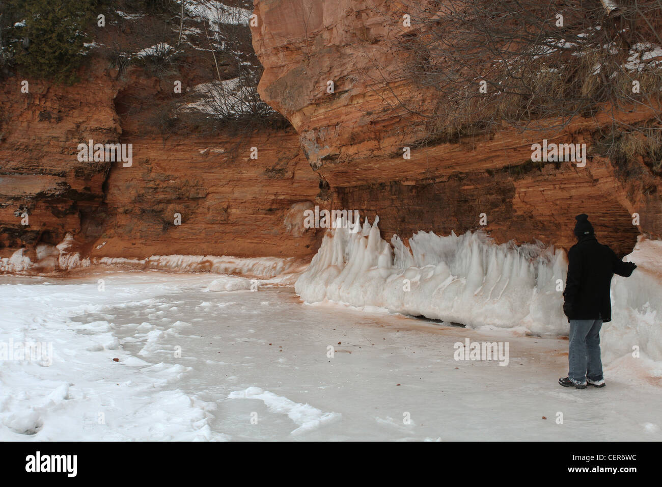 A man exploring an ice cave on the shore of Lake Superior near Cornucopia, Wisconsin. Stock Photo
