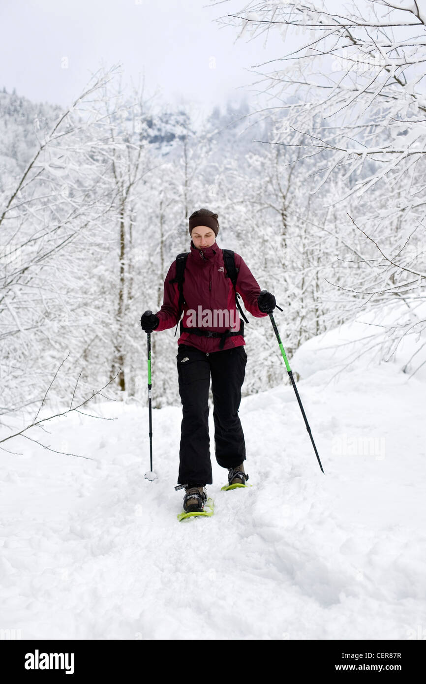 A woman walks in snow using snowshoes near Sixt Fer A Cheval in the French Alps Stock Photo