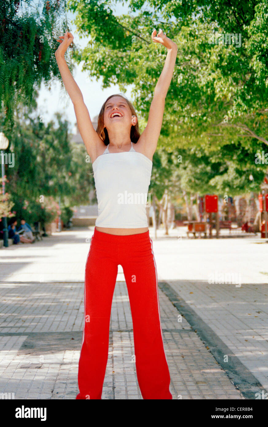 Female teenager long blonde hair wearing white top red tracksuit