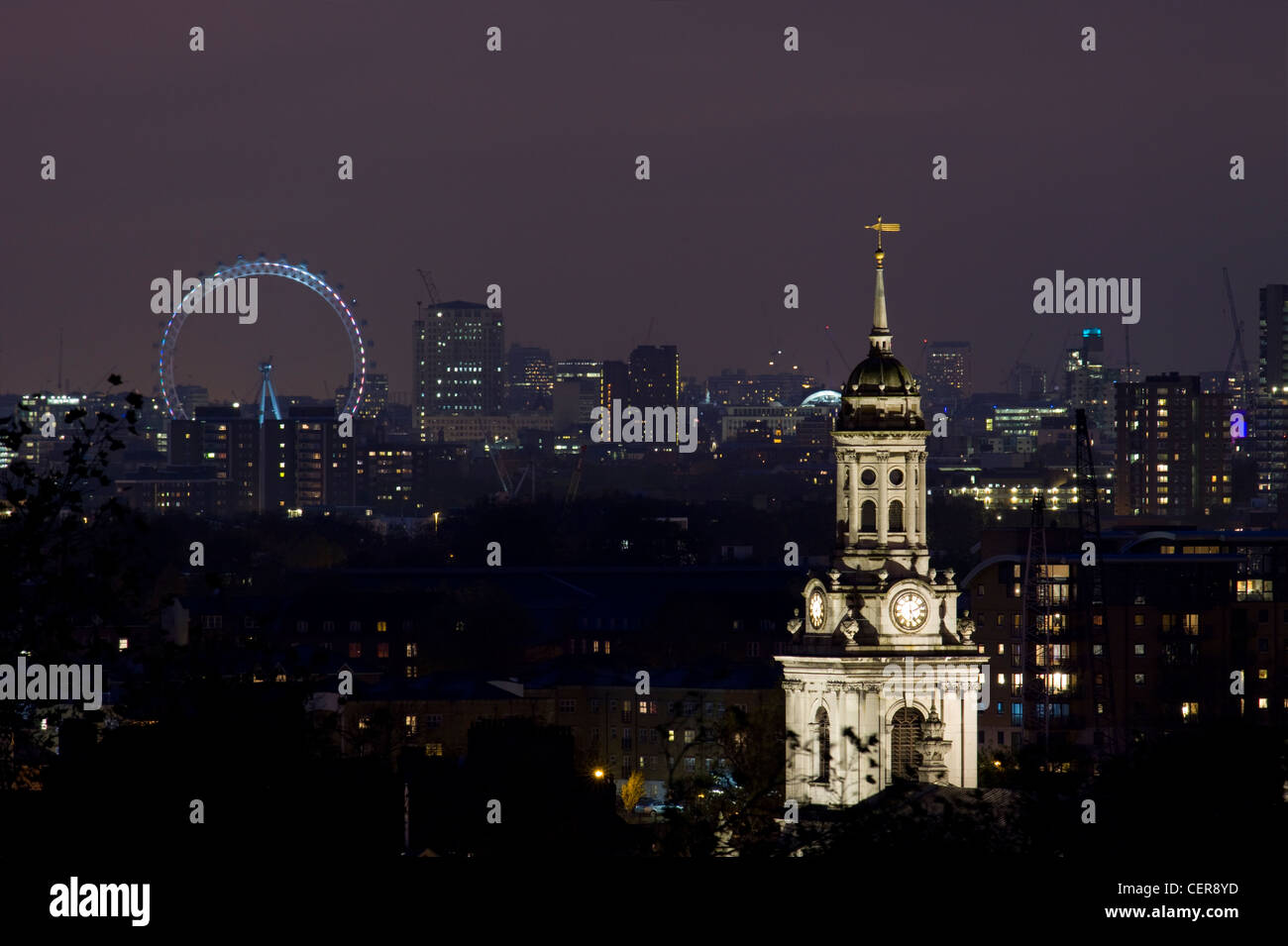 London skyline at night with a stone clock tower and the London Eye on the horizon. Stock Photo