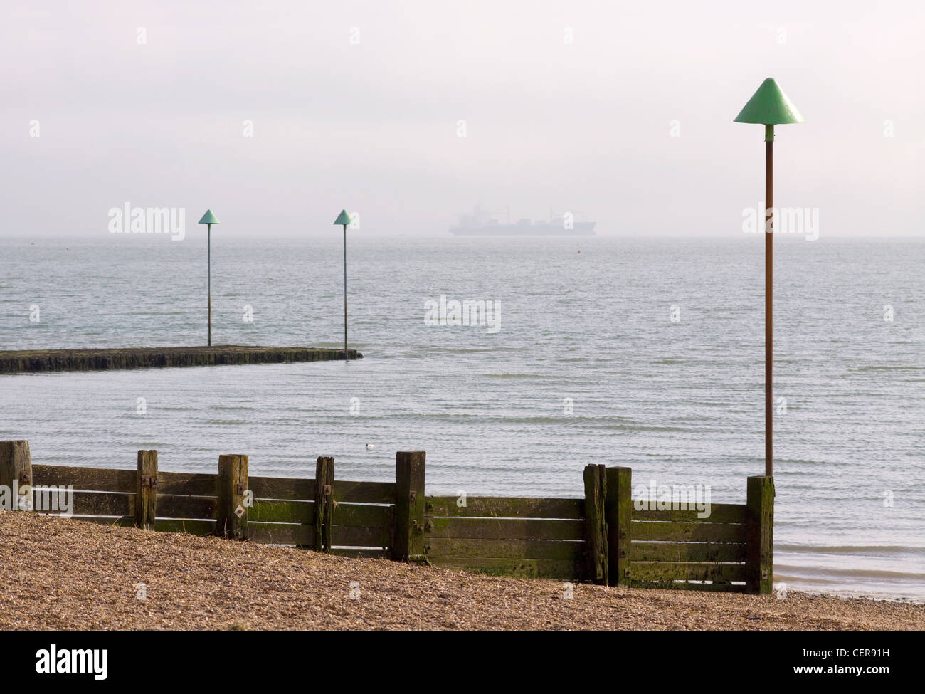 Wooden groyne on the beach at Leigh-on Sea with a ship on the horizon. Stock Photo