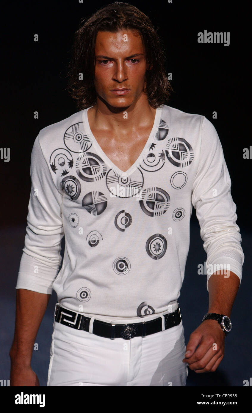 Versace Milan Menswear S S Male wearing patterned white v neck shirt Dark runway Stock Photo