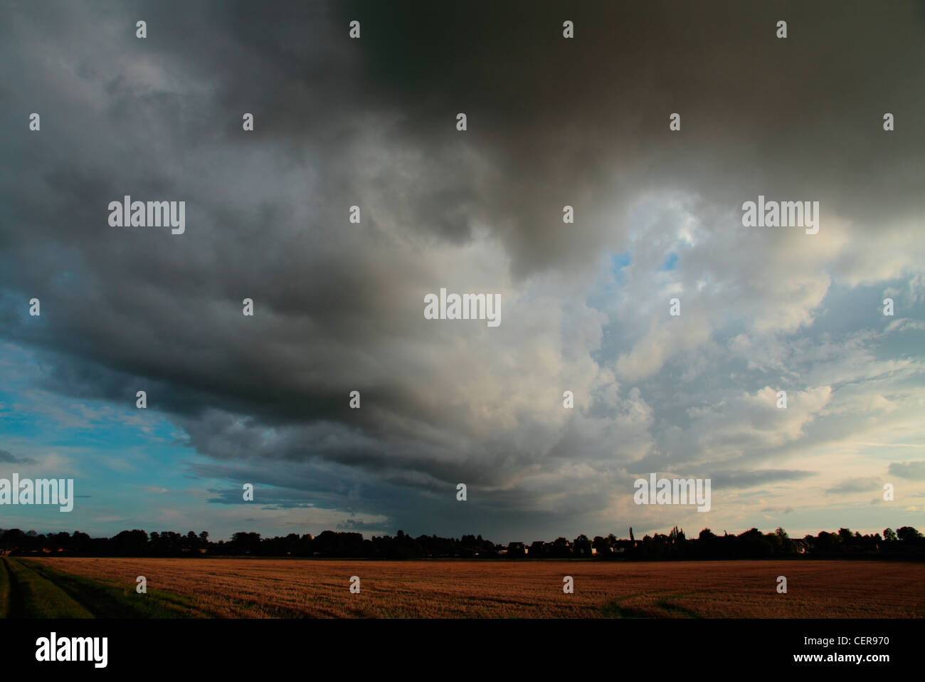 Dark storm clouds at sunset over open fields near Great Shelford. Stock Photo