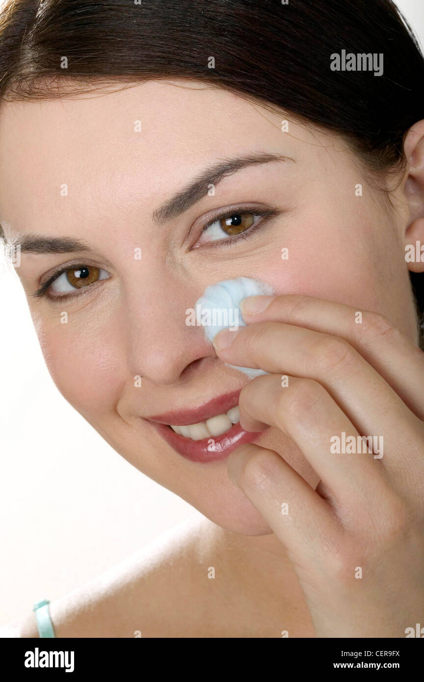 Female with hair off face holding ball of cotton wool to nose