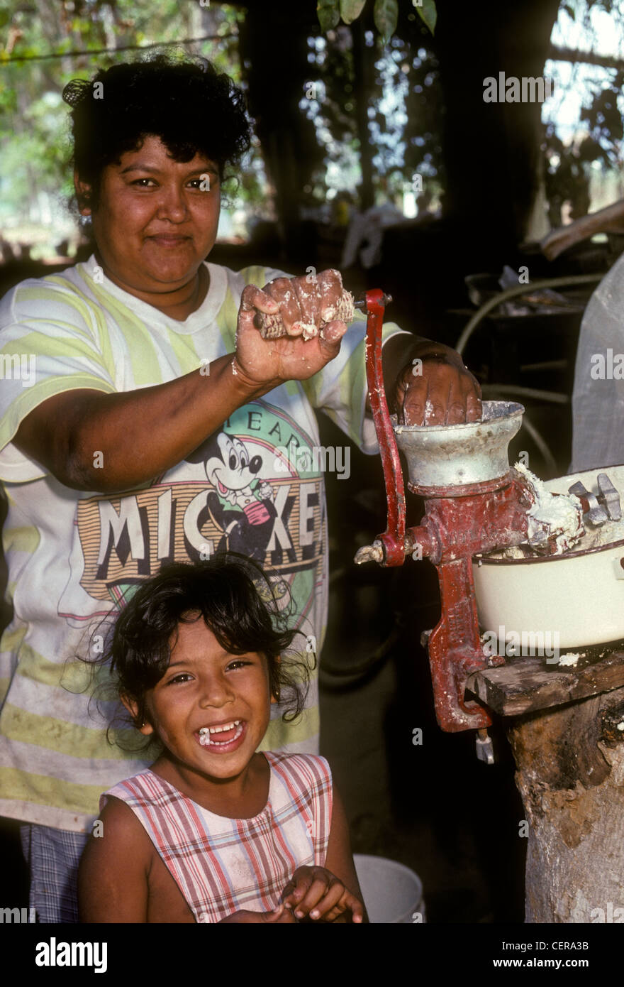 Mexican people mother and daughter adult woman grinding corn kernels making cornmeal in village of Ixtapa in Jalisco State in Mexico Stock Photo