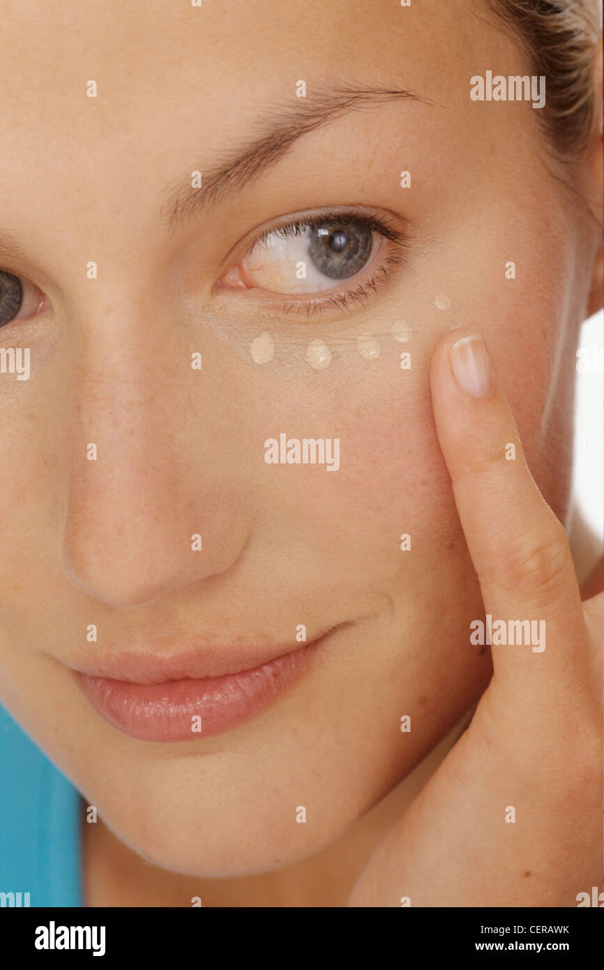 Close up of a Female face with foundation beads under one eye Stock