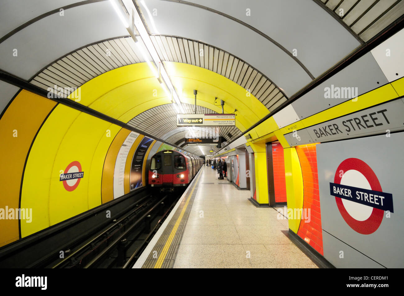 A tube train on the Jubilee line arriving alongside a platform at Baker Street Underground Station. Stock Photo