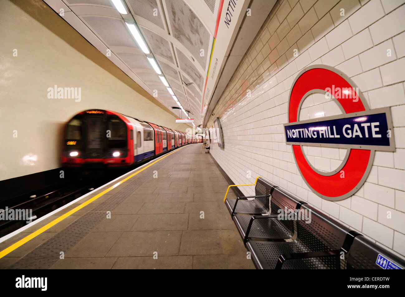A Central line tube train departing Notting Hill Gate underground station. Stock Photo