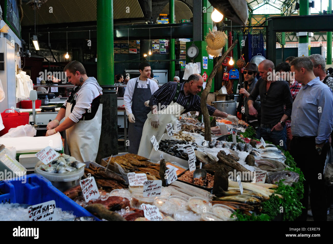 Customers buying seafood from a fishmongers stall at Borough Market. Stock Photo