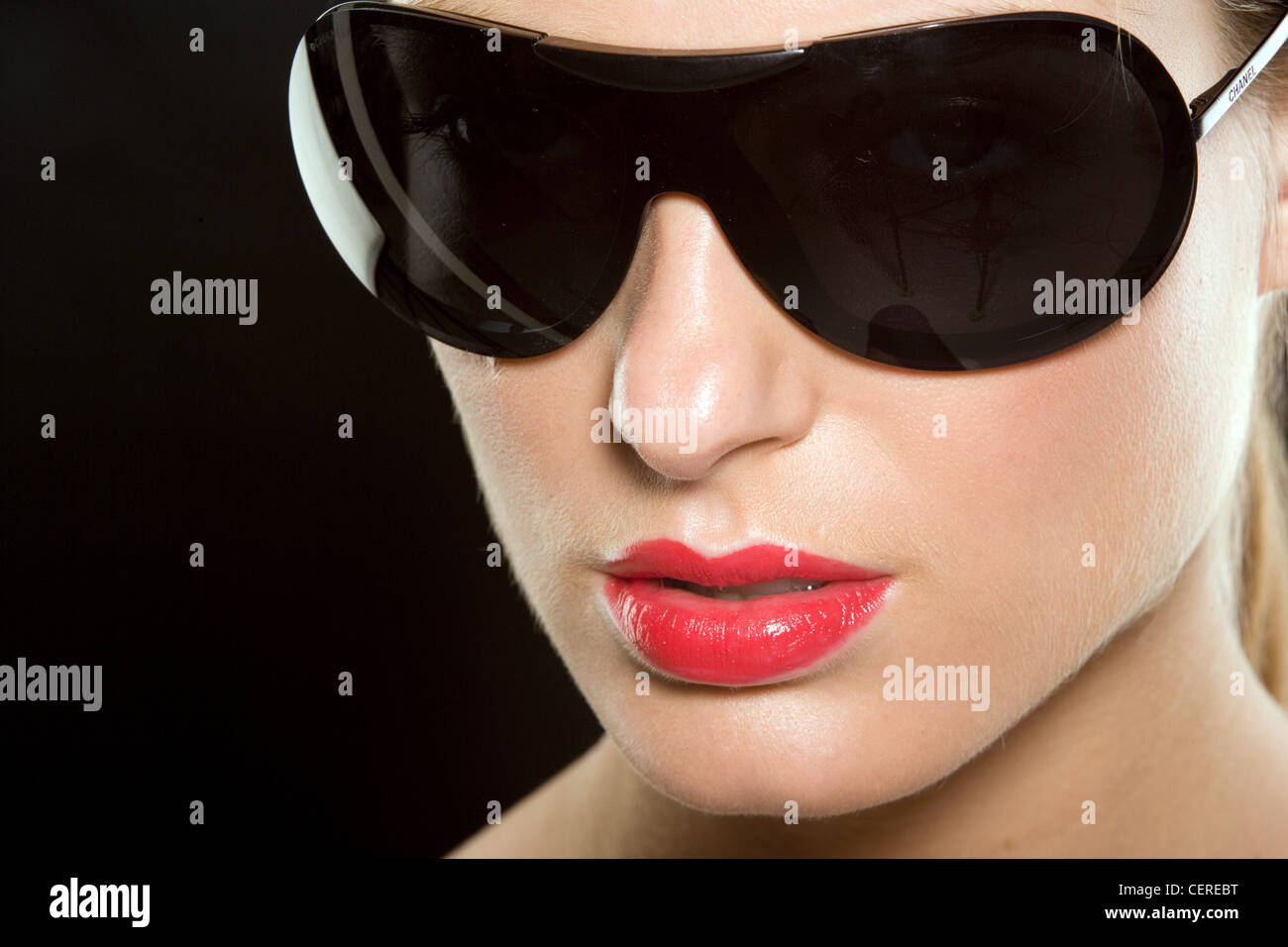 Female wearing bright red lipstick and large black sunglasses Stock