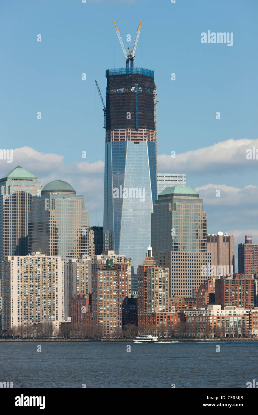 The rising One World Trade Center (Freedom Tower) and Manhattan skyline in New York City as viewed from New York Harbor. Stock Photo