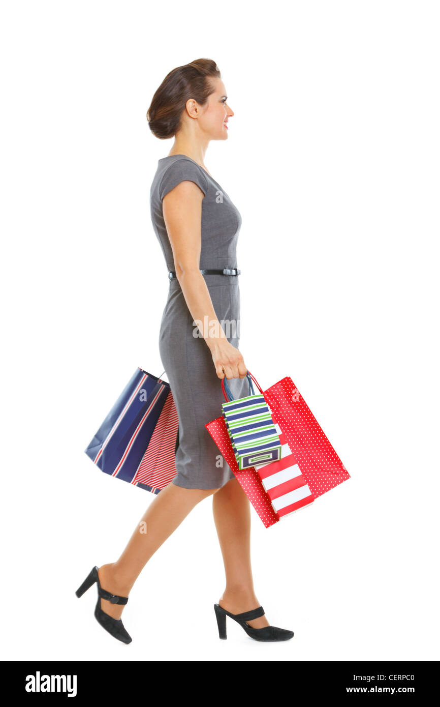 Woman in dress walking with shopping bags Stock Photo