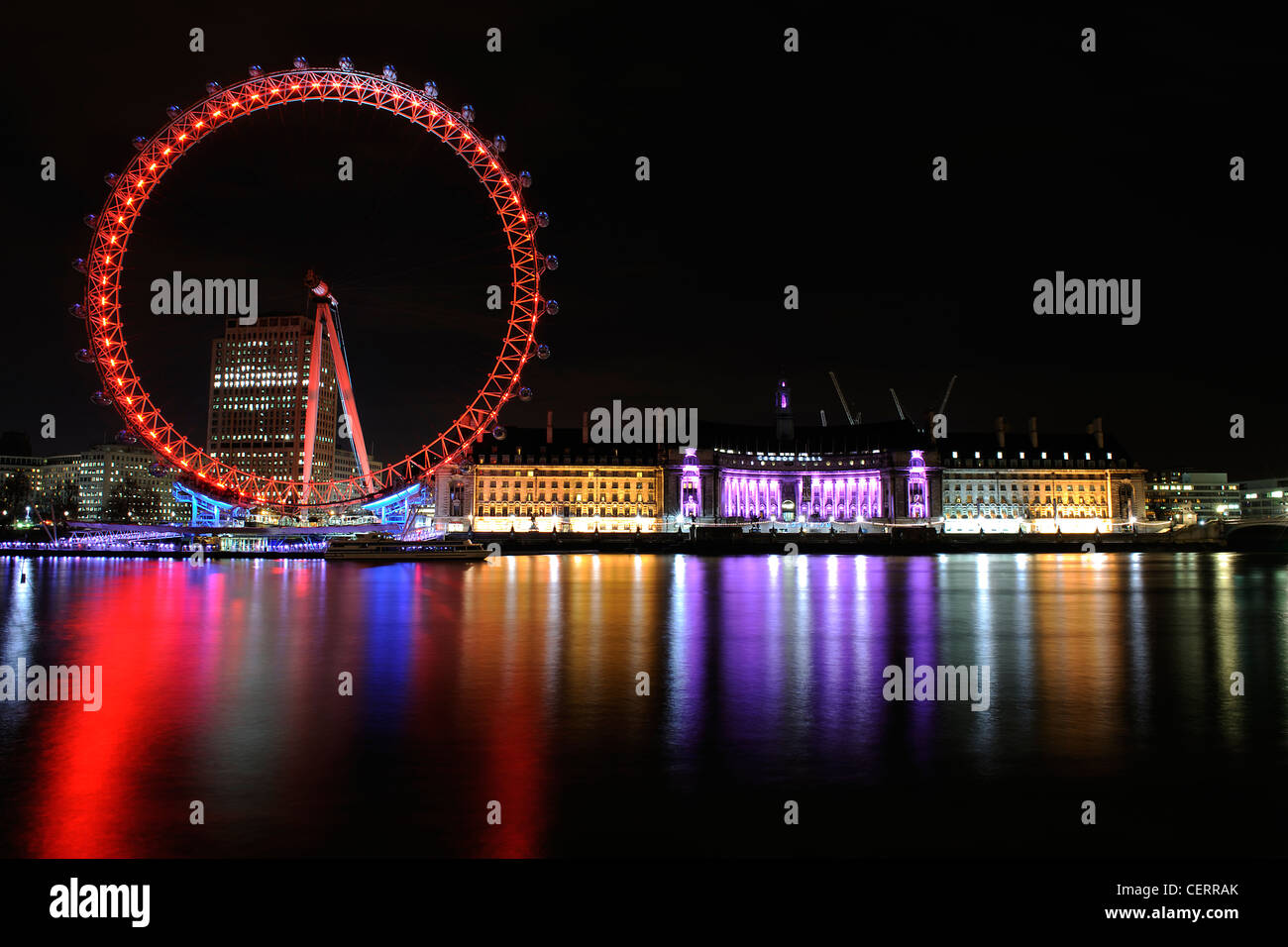 The London Eye and County Hall bathed in colourful lights on the South Bank. Stock Photo