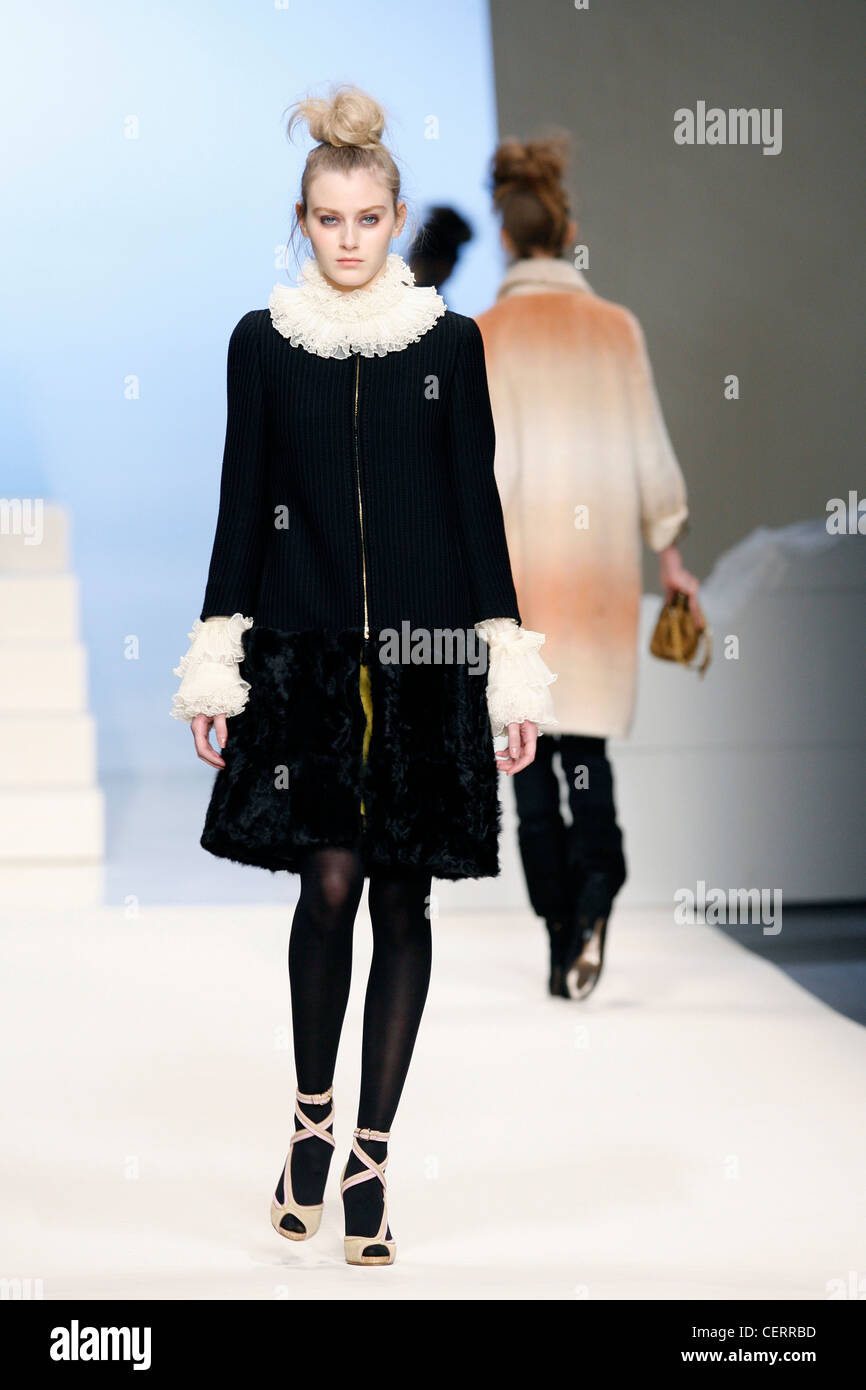 Sportmax Milan Ready to Wear Autumn Winter Model wearing a knitted dress black fur trim a white frilly shirt underneath Stock Photo