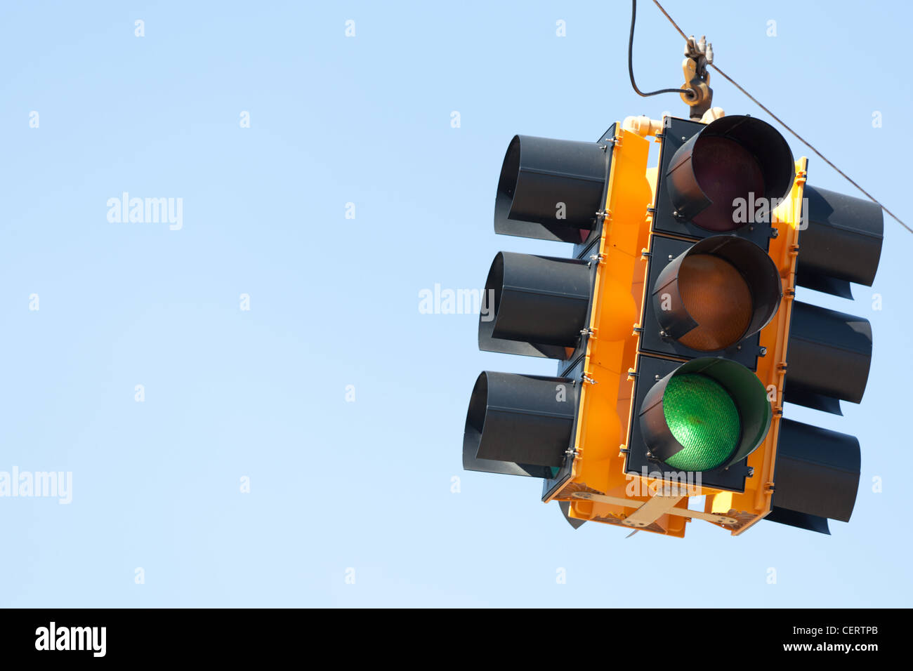 Green traffic signal or light in front of blue sky with copy space Stock Photo