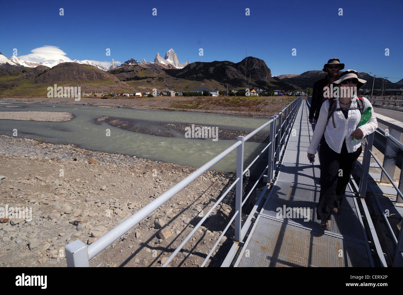 Backpackers crossing bridge in town of El Chalten, Patagonia, Argentina. No MR Stock Photo