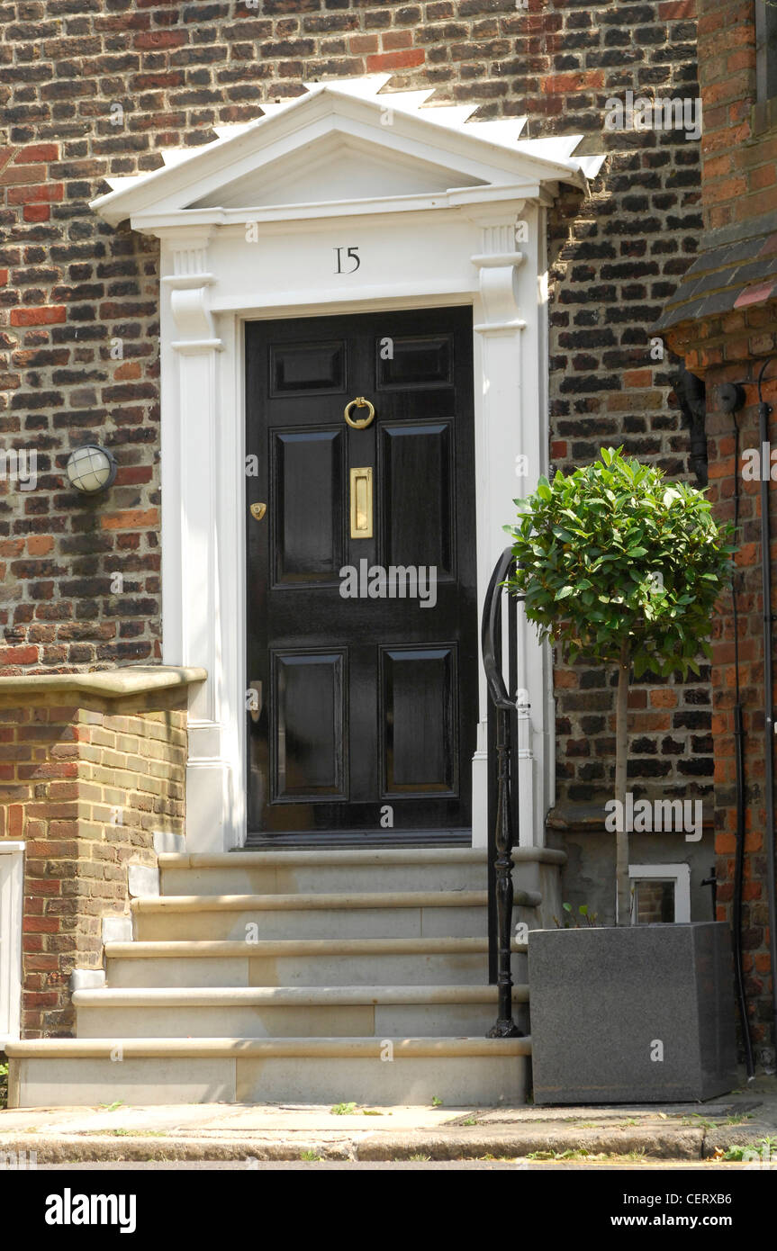 A Traditional Black Front Dowith White Pediment Stone Steps Up To