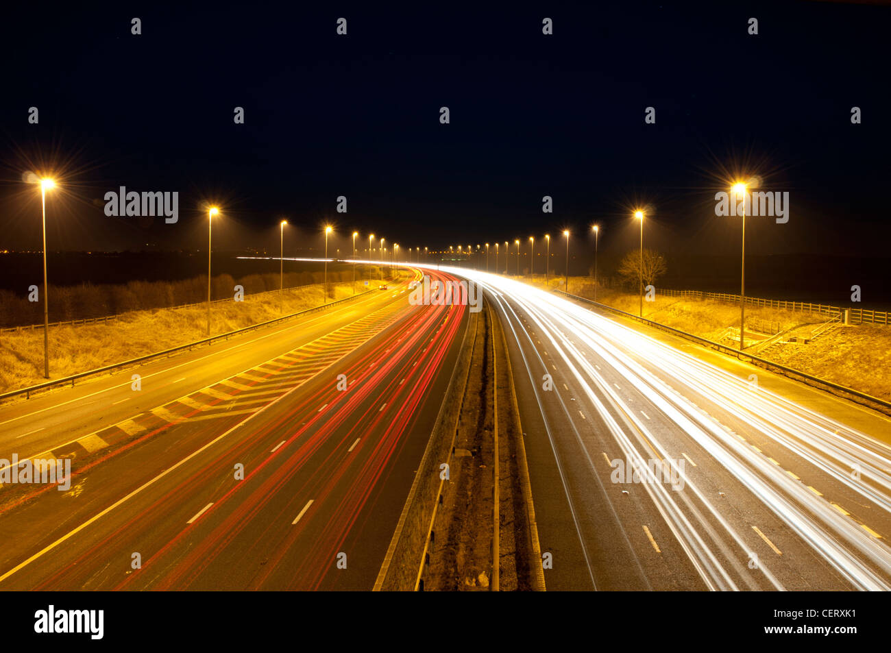 Traffic speeding past on a UK motorway at night in Cheshire Stock Photo
